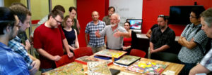 Image of Dan Cermak talking about board games to an attentive crowd. 